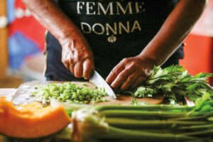 A community kitchen worker chops vegetables to provide low-cost meals to people struggling with inflation and rising food prices.