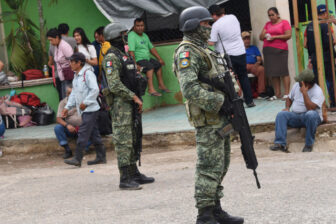 Soldiers help villagers at an emergency shelter on June 11 after violent conflict in southern Mexico.