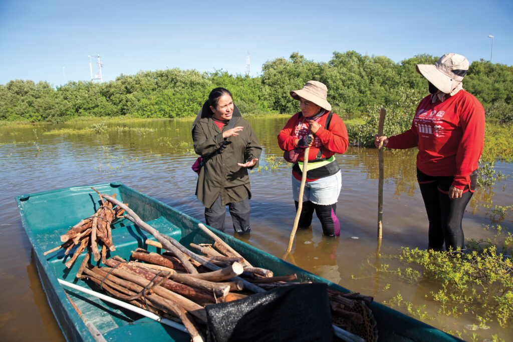 Right: Biologist Claudia Teutli Hernández, left, from the University of Barcelona, discusses a restoration site with Chelemeras Keila Vásquez Lira, center, 42, and Angie Alejandra Martínez Castillo, 49, in October.