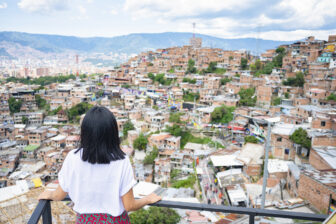 A woman looks toward Comuna 13 in Medellín, Colombia. Can Latin America Regain Momentum in Fighting Poverty? Despite significant progress, the region has seen a slowdown in poverty reduction. A set of key public policies can help, writes a World Bank economist.