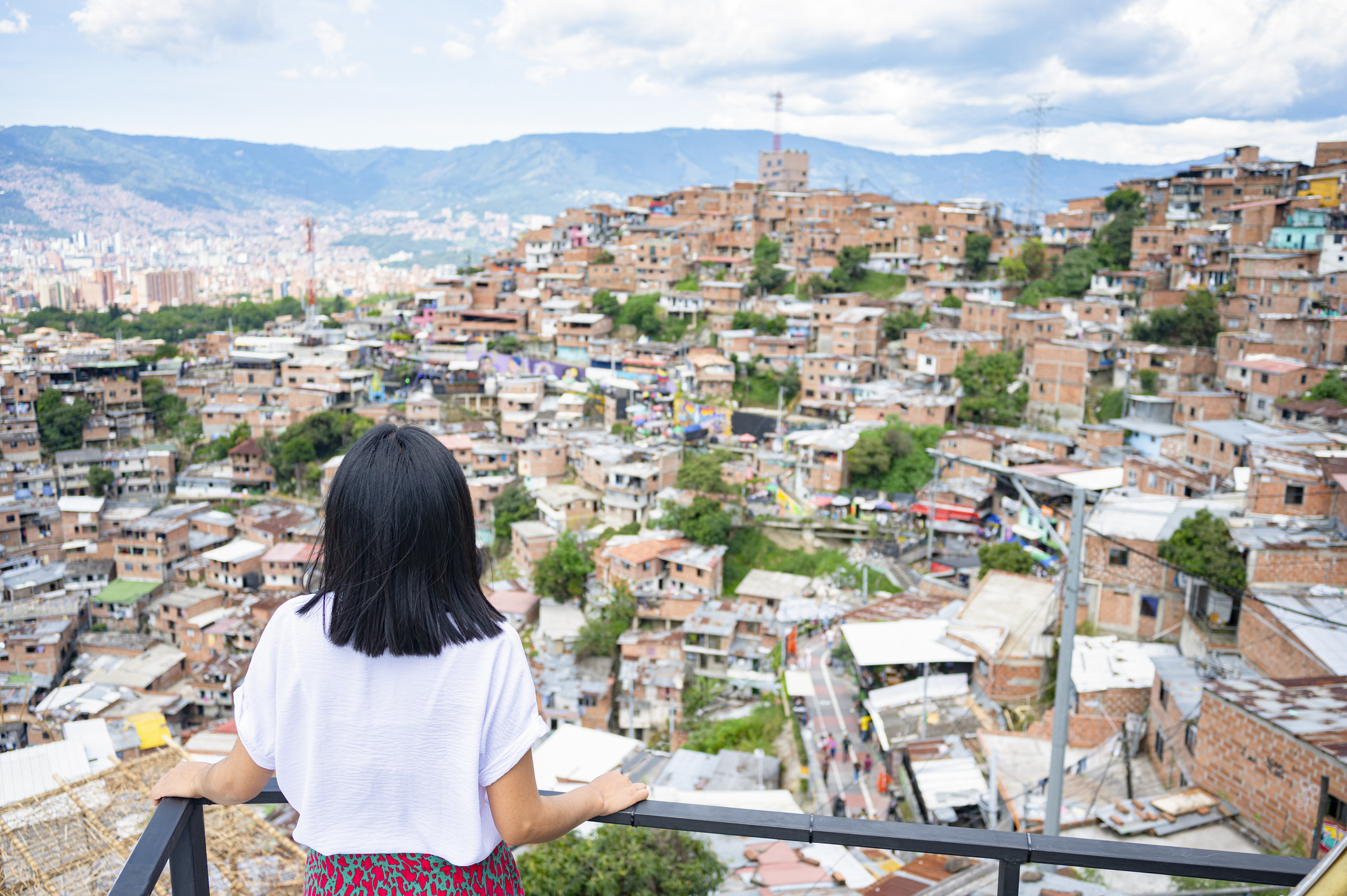 A woman looks toward Comuna 13 in Medellín, Colombia. Can Latin America Regain Momentum in Fighting Poverty? Despite significant progress, the region has seen a slowdown in poverty reduction. A set of key public policies can help, writes a World Bank economist.