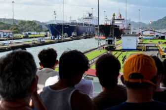 People look at two cargo ships entering the Miraflores Locks of the Panama Canal on January 22.