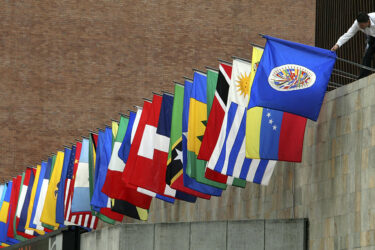 A worker prepares the flags of the Organization of American States (OAS) outside a press conference on May 30, 2008 in Medellin. The 38th regular session of the OAS General Assembly will be held from June 1 to 3 in Medellin, Colombia.