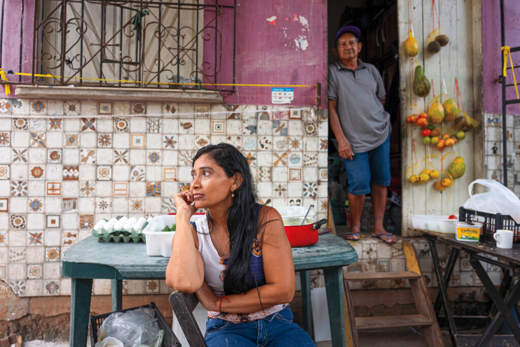 “They’re paving the avenue, but our house still has no sewage.” —Ana Maria Corrêa, 38, who lives beside the Murutucu Canal, sits outside her home. Although the canal is under construction, her house still lacks basic sanitation services.