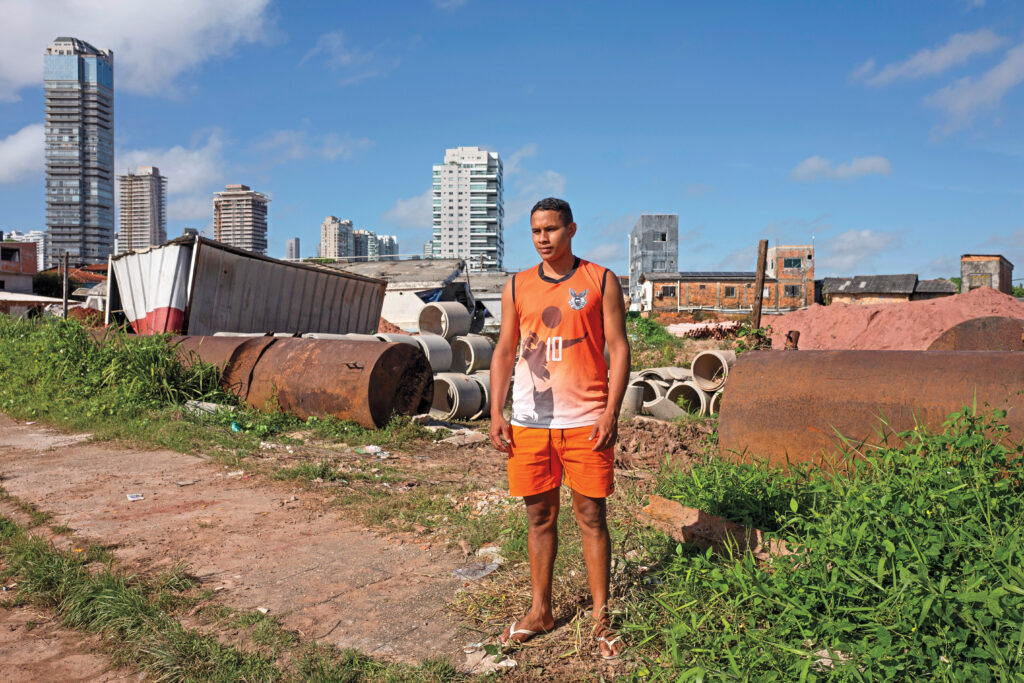 “We don’t play anymore.” —Fernando Carvalho, 23, a local resident, stands where he used to play soccer. The field in front of his home has been transformed into a construction debris site due to COP30.