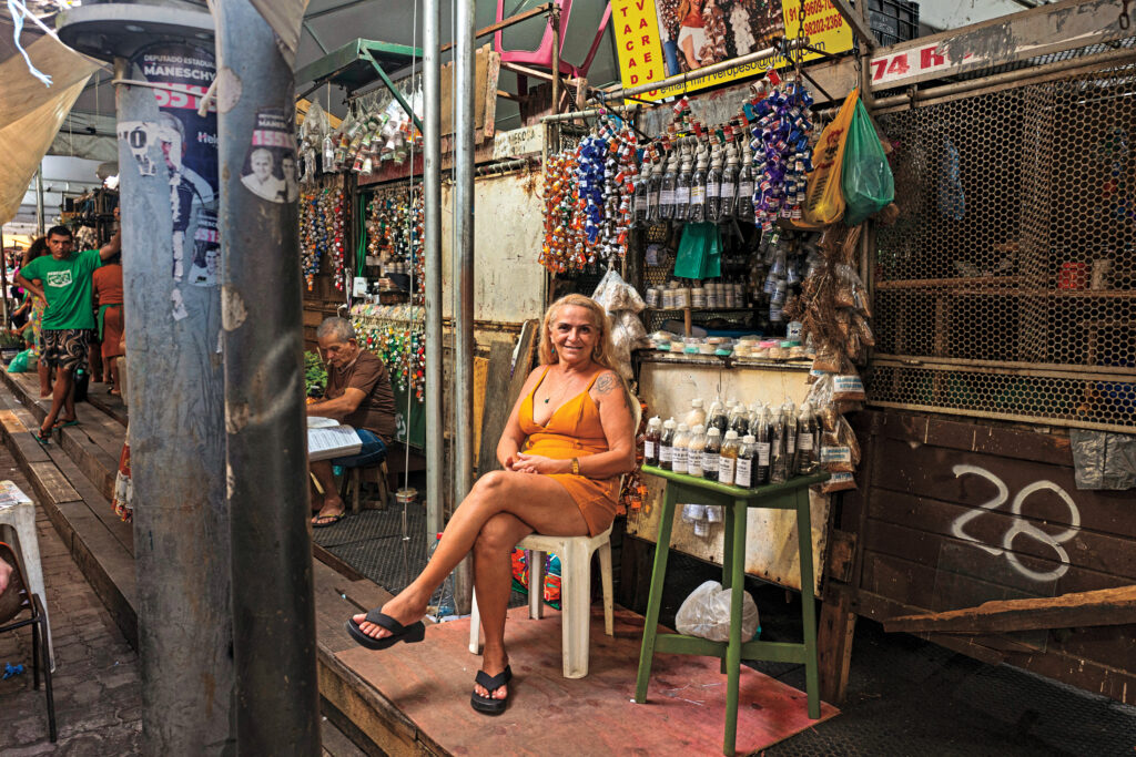 “By 4 p.m., I feel like I’m burning. I have to go home, take a shower, and jump in the pool. I built one just to survive.” —Maria Loura, 57, an herbalist, poses in the temporary medicinal herb section of Ver-o-Peso. Herbalists are among the market’s most iconic figures, selling traditional remedies deeply connected to Indigenous pharmacology.