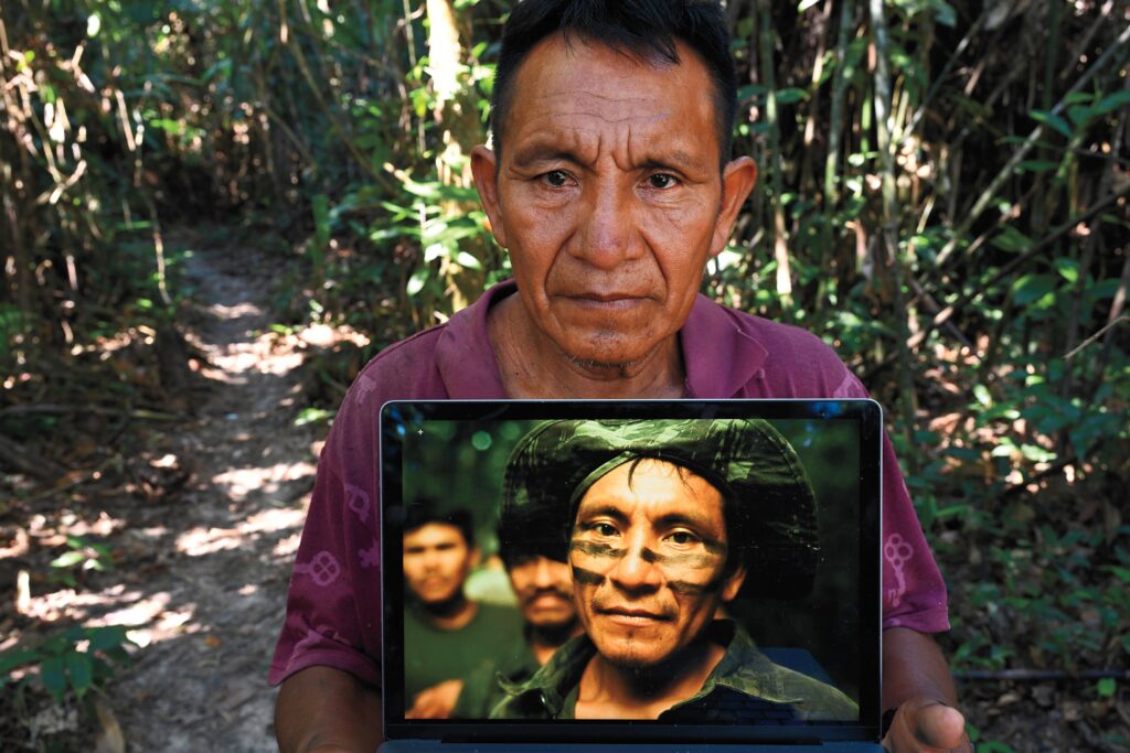 João Kanamari of the Kanamari tribe holds a laptop displaying a photo of himself taken by the author on a 2002 expedition to determine the well-being of an "uncontacted" tribe. He is now a member of a new Indigenous vigilance unit protecting the Javari. Photo by Scott Wallace.