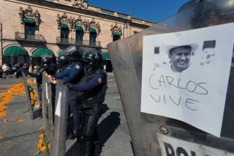 Police officers stand guard in Morelia, Michoacán state on Nov. 3 as protesters demonstrate against the assassination of Uruapan Mayor Carlos Manzo.