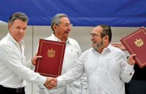 Colombia’s President Juan Manuel Santos (left) and Timoleón Jiménez, known as “Timochenko” (right), the FARC’s leader, shake hands in Cartagena in 2016 before the Peace Accord was finalized. Cuba’s President Raúl Castro (center) accompanied them.