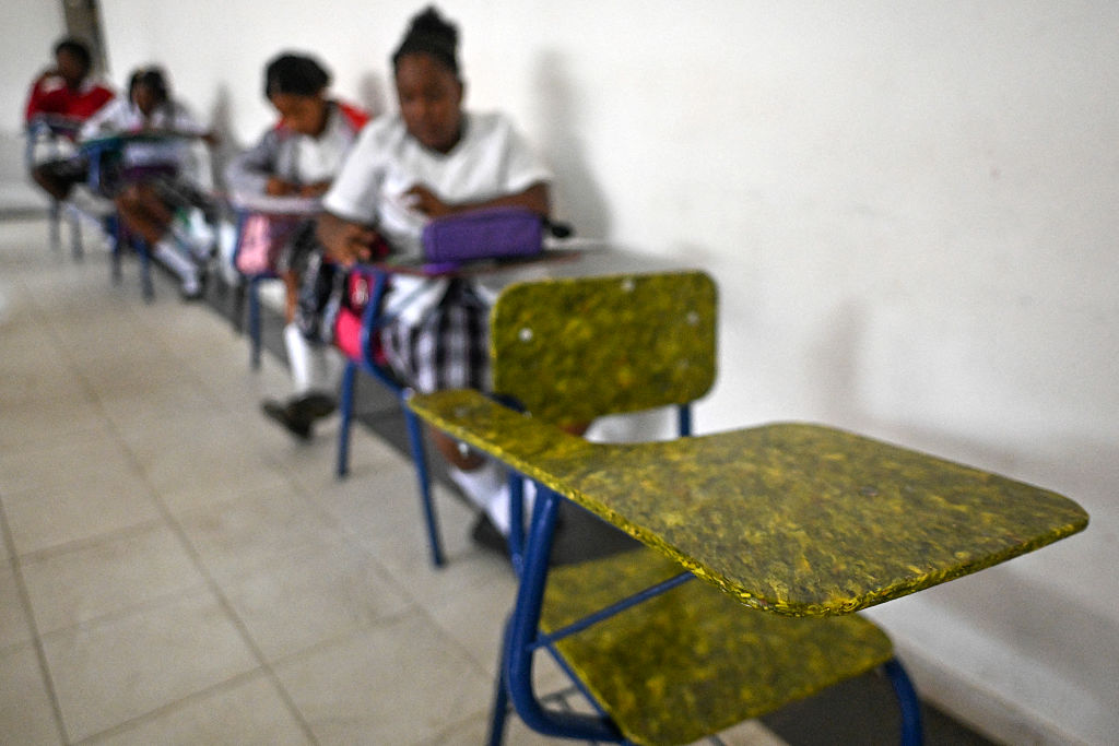 Students sit at recycled plastic school desks in Juanchaco, near Buenaventura, Colombia, in 2024.