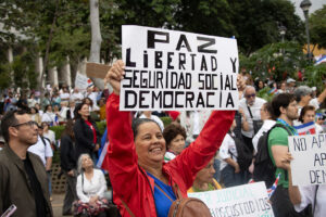 A protester in San José, Costa Rica, holds a sign expressing one definition of democracy in August.