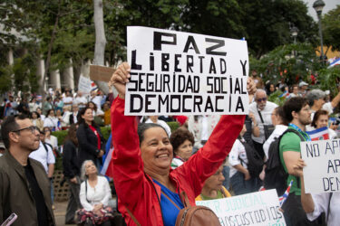 A protester in San José, Costa Rica, holds a sign expressing one definition of democracy in August.