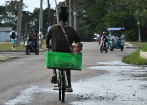 A man rides a bicycle with a boy in a basket during a blackout in Havana on September 18, 2026.