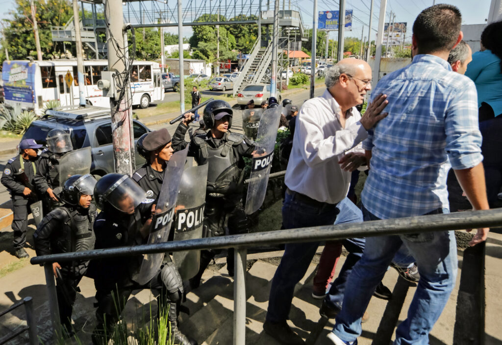 Police clear Carlos Fernando Chamorro and other journalists from outside a Managua police station in 2018.