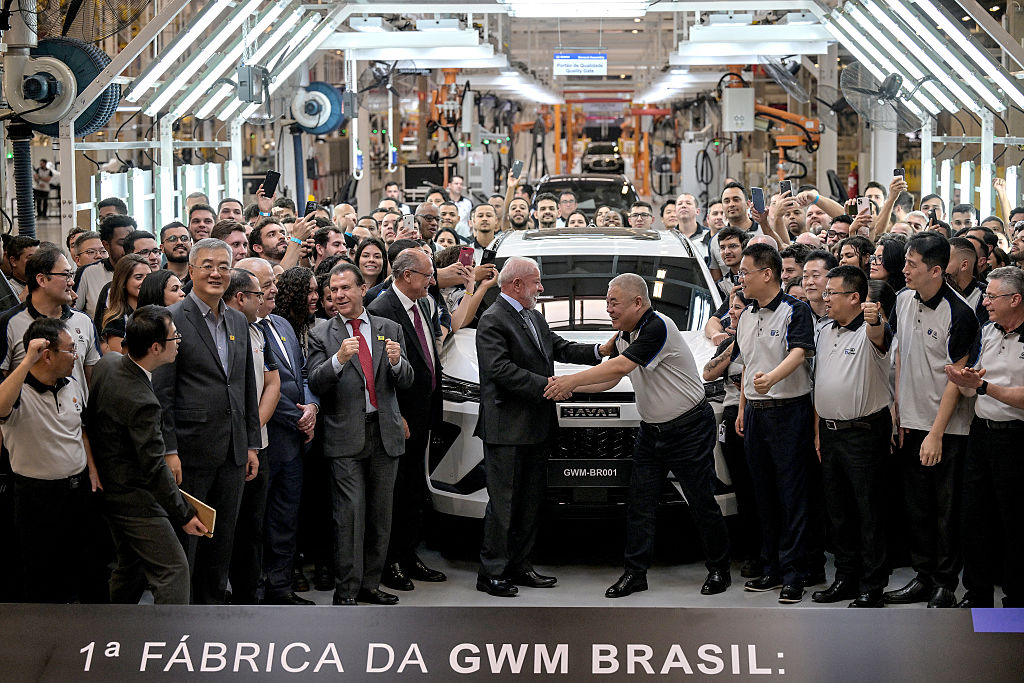Brazil's President Luiz Inácio Lula da Silva (C-L) shakes hands with China's Great Wall Motor CEO Mu Feng (C-R) during the inauguration of the GWM automobile factory in Iracemapolis, São Paulo state in Aug. 2025